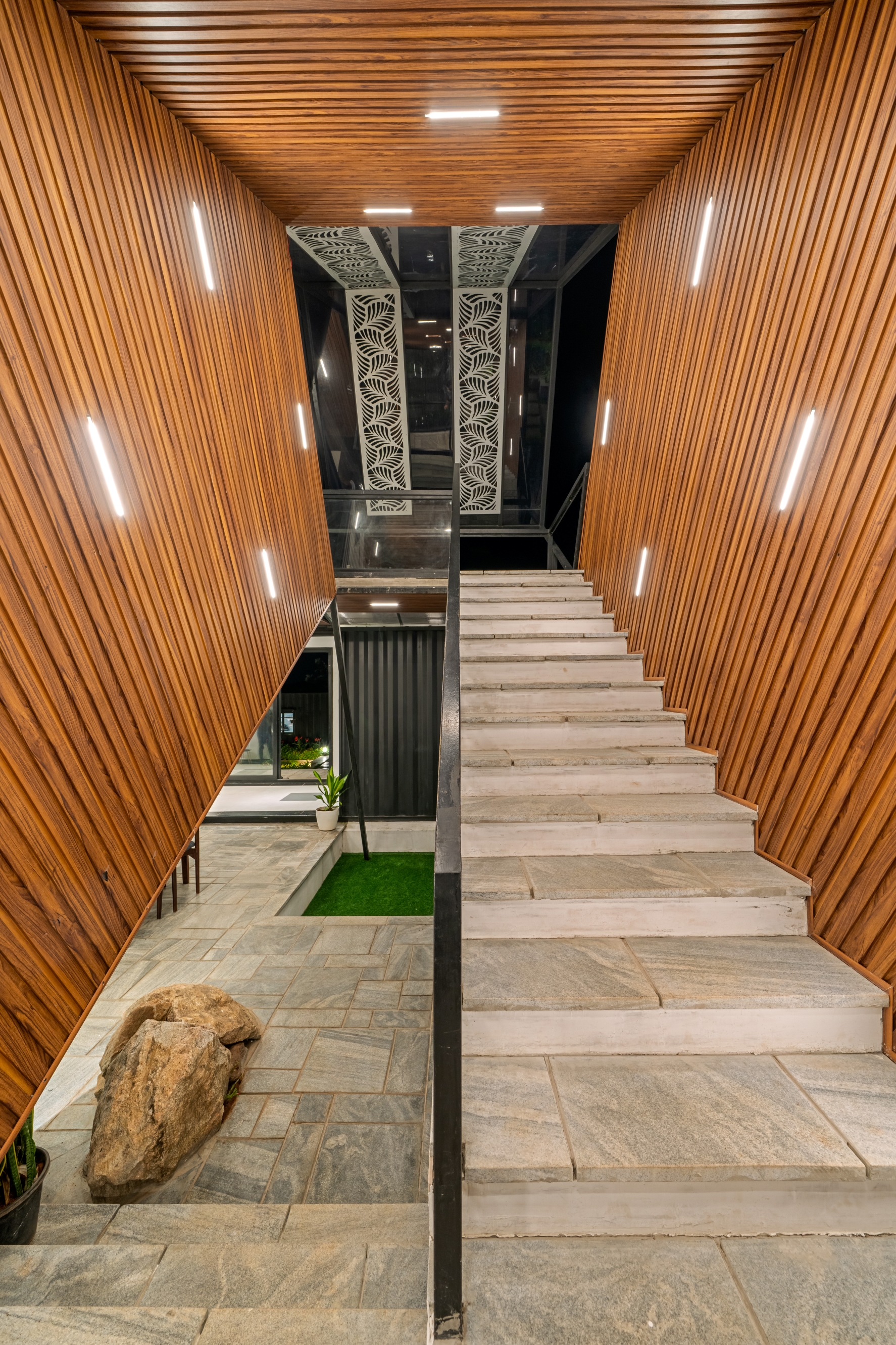 Dramatic wood-panelled staircase with warm accent lighting